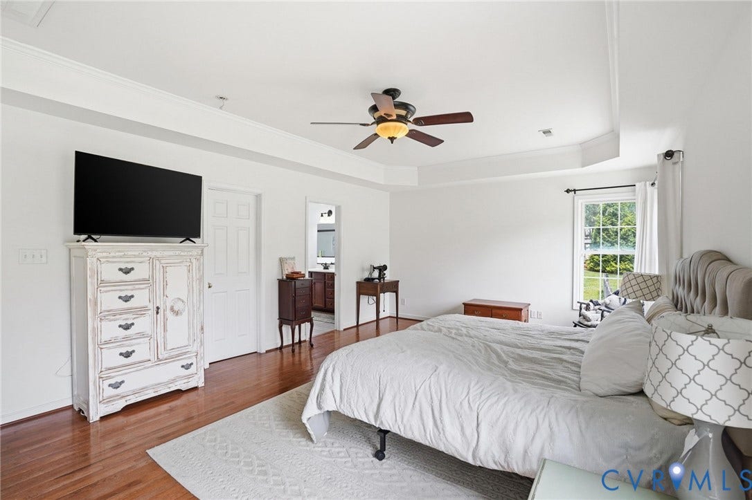 5305 Wellington Ridge Road, Richmond, VA 23231 Spacious bedroom featuring wood-finish flooring, a tray ceiling with a ceiling fan, and crown molding
