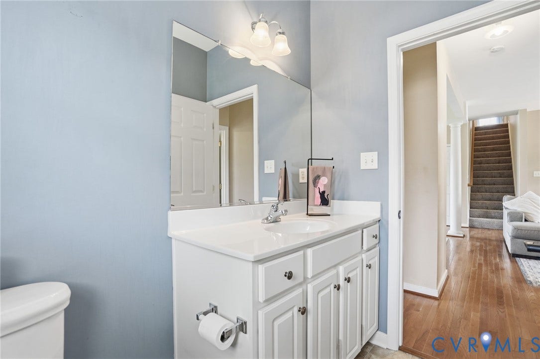 5305 Wellington Ridge Road, Richmond, VA 23231 Bathroom vanity with a white countertop and integrated sink, chrome faucet, and white cabinetry with dark hardware