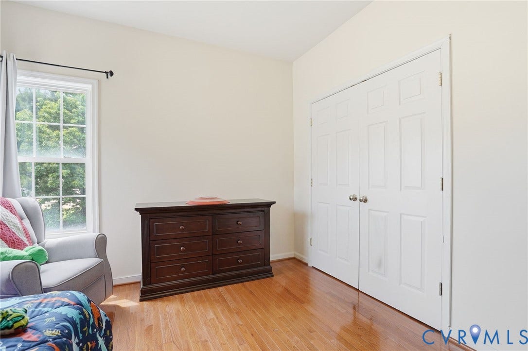 5305 Wellington Ridge Road, Richmond, VA 23231 Bright interior space featuring wood-finish flooring, a white paneled bi-fold closet, a double-hung window, and light-toned wall finishes
