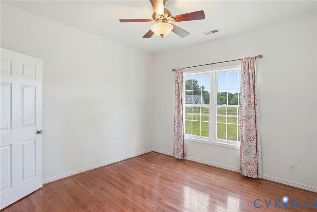 5305 Wellington Ridge Road, Richmond, VA 23231 Bright room featuring wood-finish flooring, white walls, and a multi-pane window overlooking a green landscape