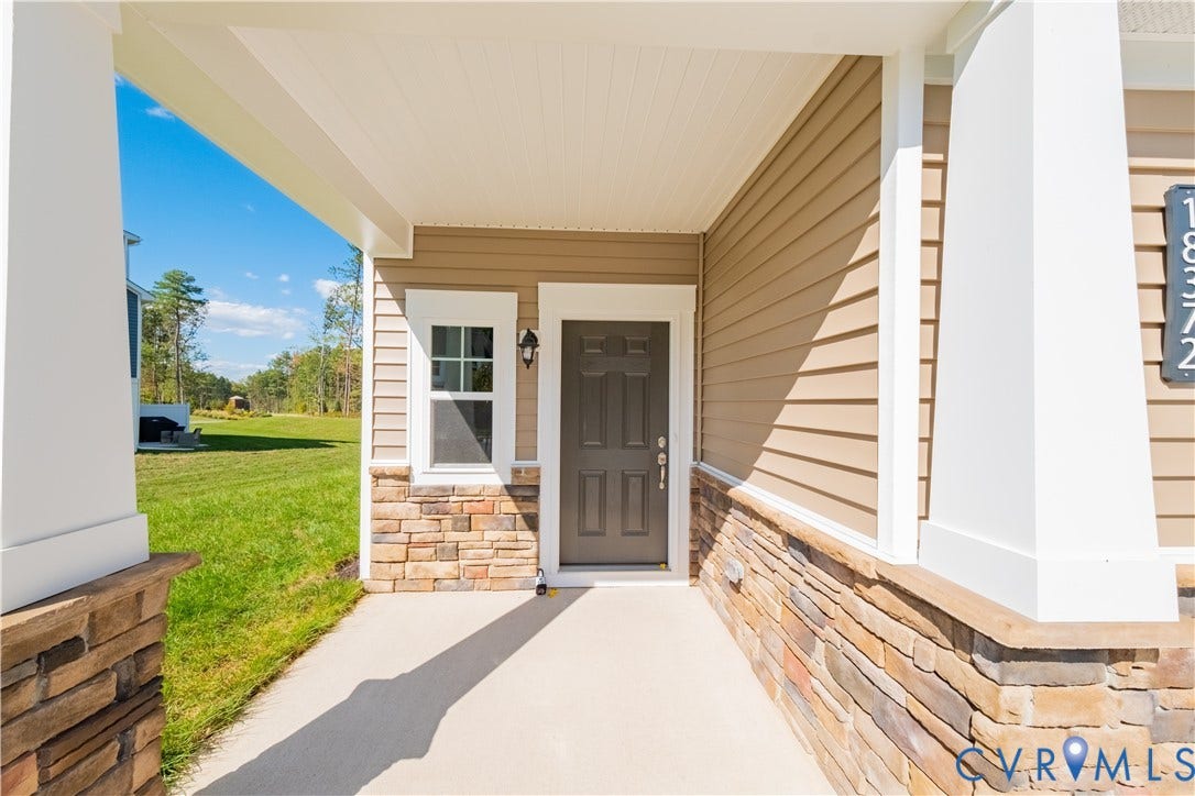 18372 Palisades Court, Chesterfield, VA 23120 Covered front porch featuring stacked stone accents, vinyl siding, a paneled entry door, and an exterior light fixture