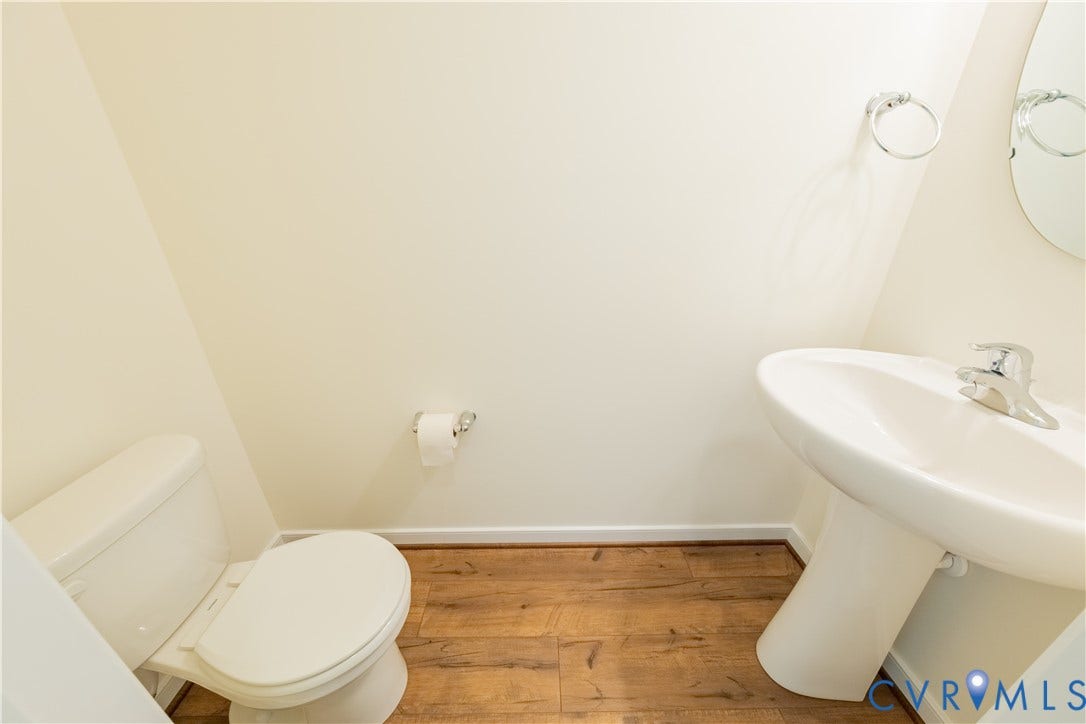 18372 Palisades Court, Chesterfield, VA 23120 Pedestal sink with chrome faucet, complemented by wood-finish flooring
