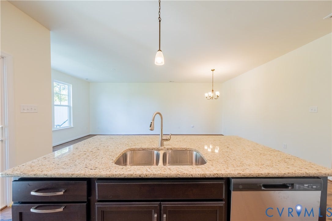 18372 Palisades Court, Chesterfield, VA 23120 Kitchen island featuring a double basin stainless steel sink with a gooseneck faucet, granite countertops, dark wood cabinetry, and a built-in stainless steel dishwasher