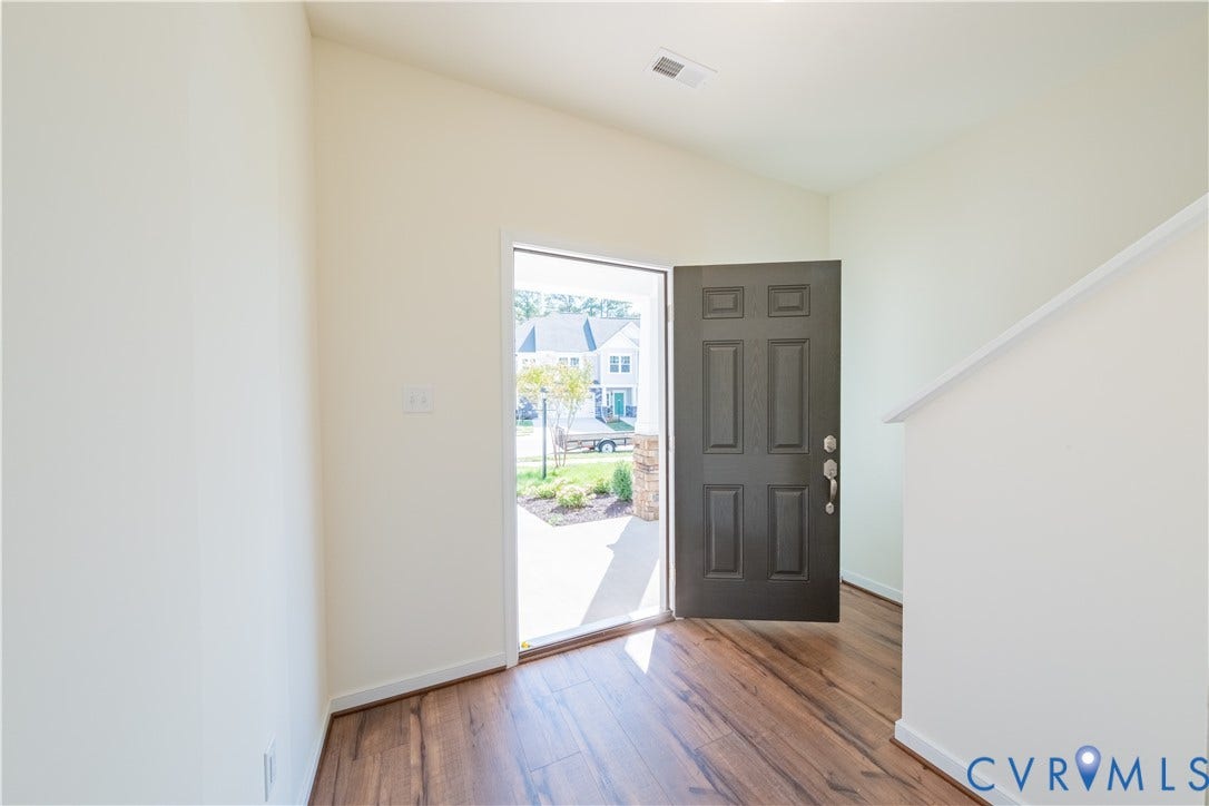 18372 Palisades Court, Chesterfield, VA 23120 Welcoming entry hall featuring a dark-paneled front door, wood-finish flooring, and light-toned walls