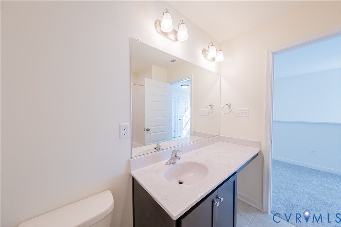 18372 Palisades Court, Chesterfield, VA 23120 Bathroom featuring a single vanity with a white countertop, under-mount sink, chrome faucet, and dark wood-finish cabinetry
