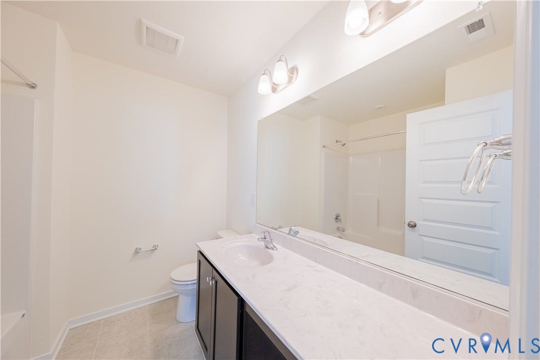 18372 Palisades Court, Chesterfield, VA 23120 Bathroom featuring a dark wood-finish vanity with a single basin sink, light-colored countertop, and a large wall-mounted mirror