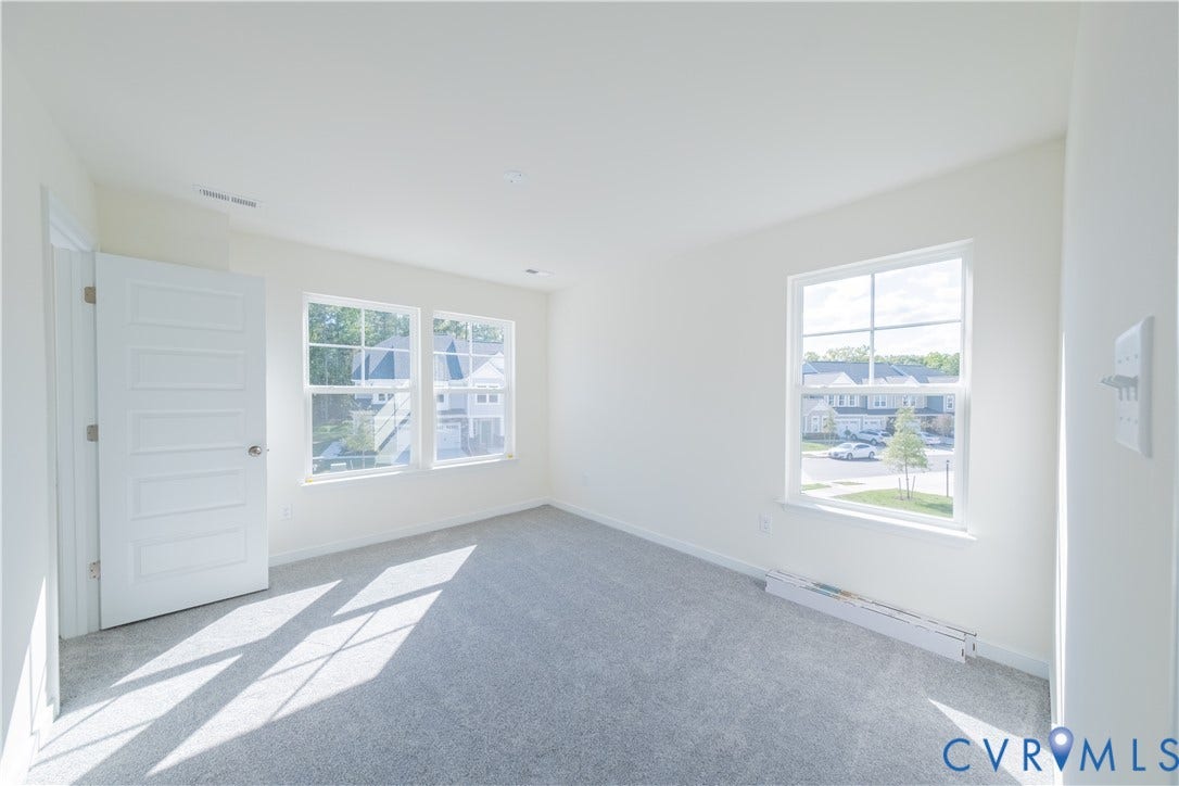 18372 Palisades Court, Chesterfield, VA 23120 Spacious room featuring light gray carpeting, crisp white walls, and multiple windows providing natural illumination