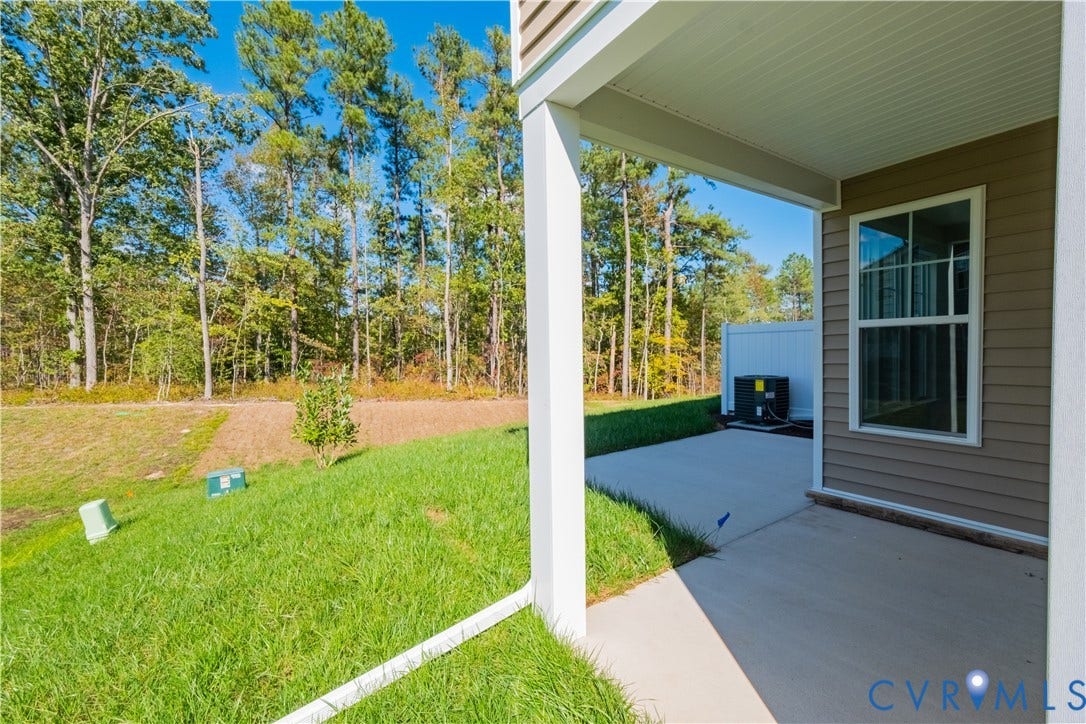 18372 Palisades Court, Chesterfield, VA 23120 Covered patio with concrete flooring, siding exterior, and a manicured lawn backing to a wooded area