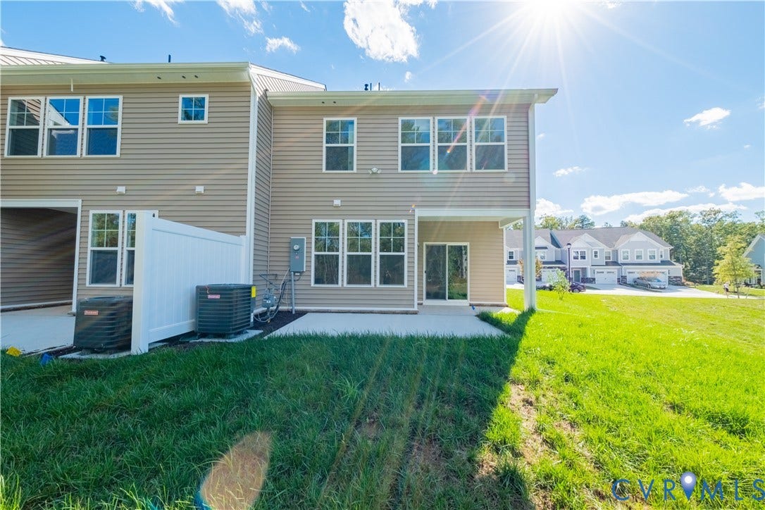 18372 Palisades Court, Chesterfield, VA 23120 Rear exterior featuring neutral-toned siding, a ground-level concrete patio, and a sliding glass door