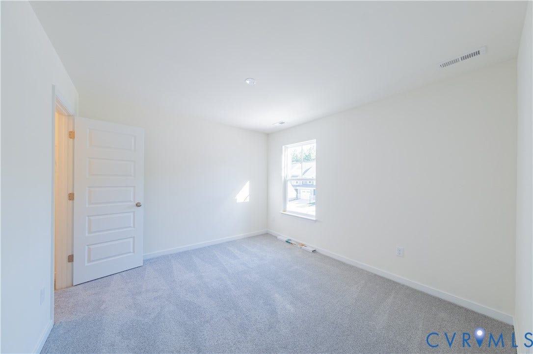 18372 Palisades Court, Chesterfield, VA 23120 Room featuring light gray carpeting, a window with exterior views, white walls, and a five-panel interior door