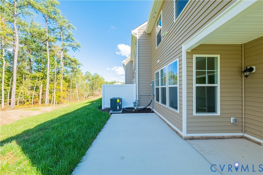 18372 Palisades Court, Chesterfield, VA 23120 Concrete patio with a covered section, tan siding, multiple windows, and a white privacy fence