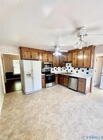 Kitchen with wood cabinetry, light-toned flooring, and white and black tile backsplash