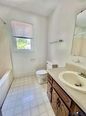 Bathroom featuring a white bathtub, toilet, and vanity with a built-in sink