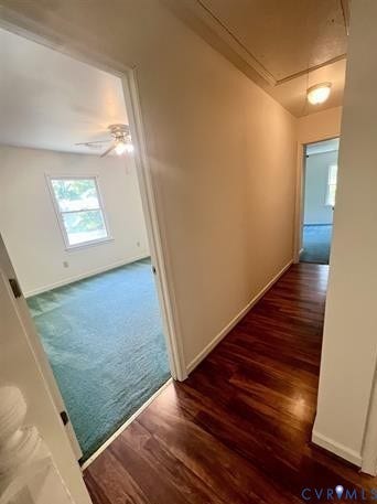 Hallway featuring wood-finish flooring, light-colored walls, and a ceiling-mounted light fixture
