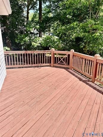 Spacious outdoor deck featuring wood flooring and sturdy wood railings