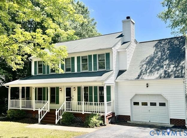Traditional-style exterior featuring white siding, green shutters, a full-width covered porch with white railings, a prominent brick chimney, and an attached single-car garage