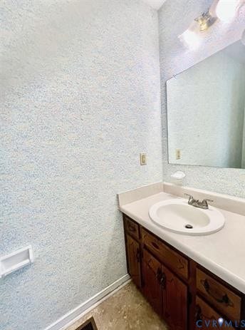 Bathroom vanity featuring a light-colored countertop with an integrated sink and chrome faucet
