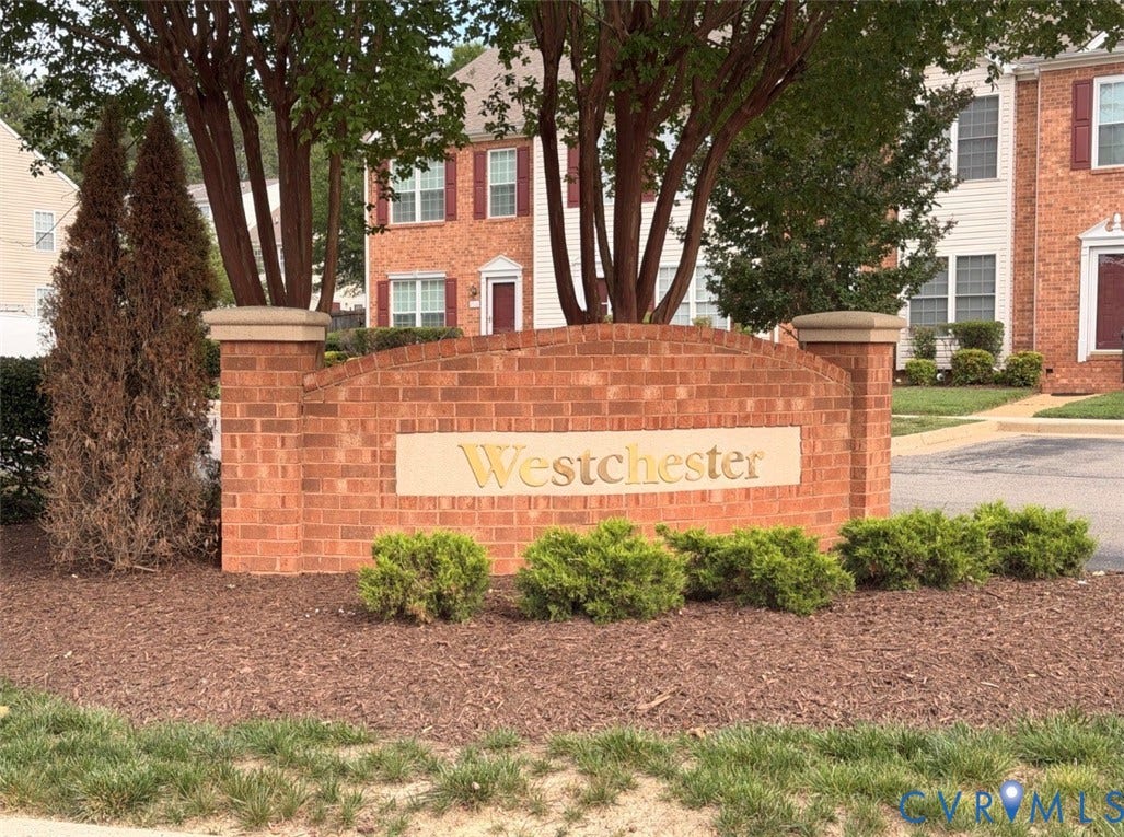 3118 Perdue Springs Lane, Chester, VA 23831 Brick community entrance sign with raised lettering, surrounded by established landscaping and mature trees