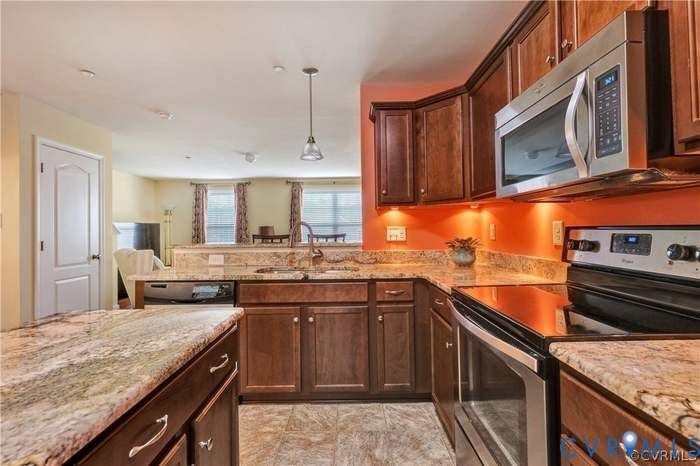 3118 Perdue Springs Lane, Chester, VA 23831 Chef's kitchen featuring rich wood cabinetry, granite countertops, stainless steel appliances, and a vibrant orange glass tile backsplash