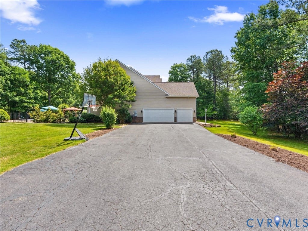 Wide paved driveway, 3 car garage.