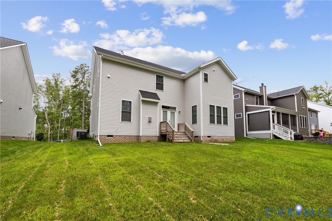 7125 Jones Run Lane, Glen Abby, Moseley, VA 23120 Rear exterior featuring light grey siding, a white double-door entry, and a wooden staircase leading to the lawn