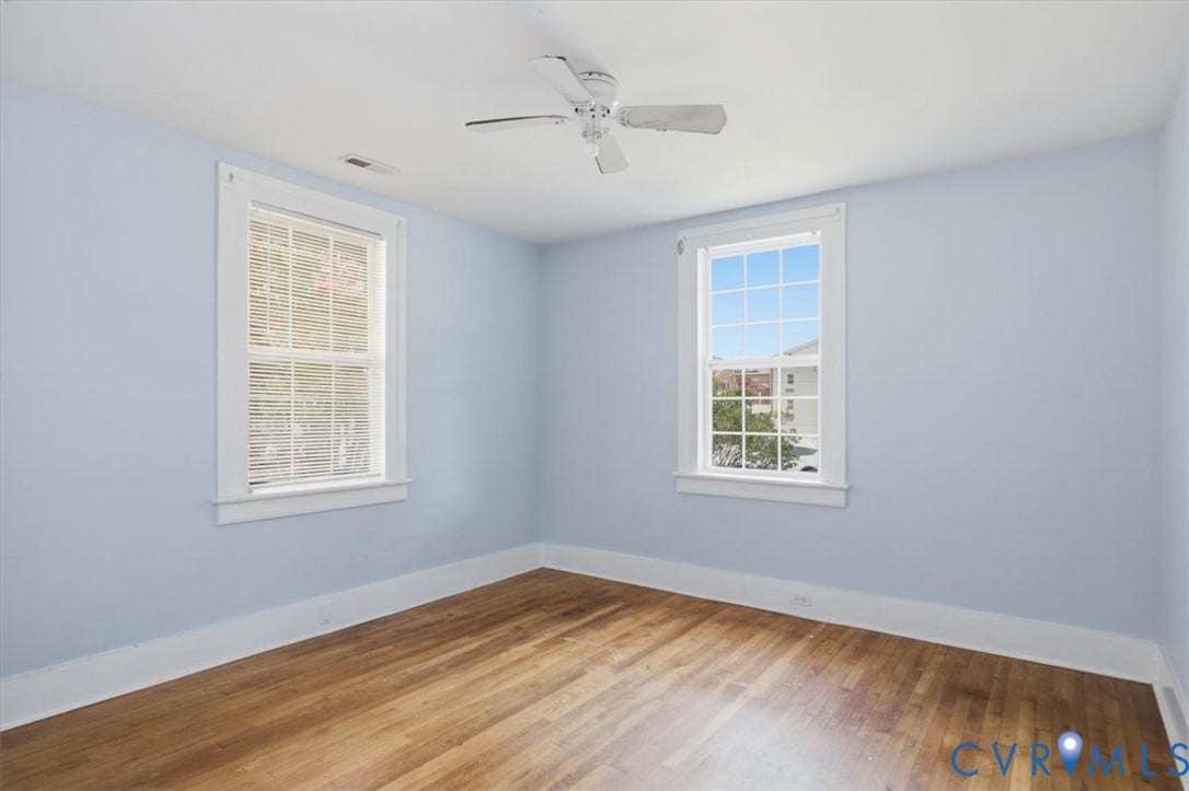 125 Richmond Avenue, Colonial Heights, VA 23834 Room featuring wood-finish flooring, two window units with white trim, a ceiling fan, and light blue wall tones