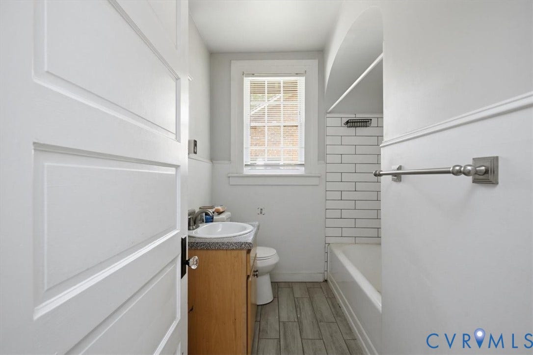 125 Richmond Avenue, Colonial Heights, VA 23834 Bathroom featuring subway tile shower surround, wood-finish flooring, a single window, and a vanity with a white basin sink