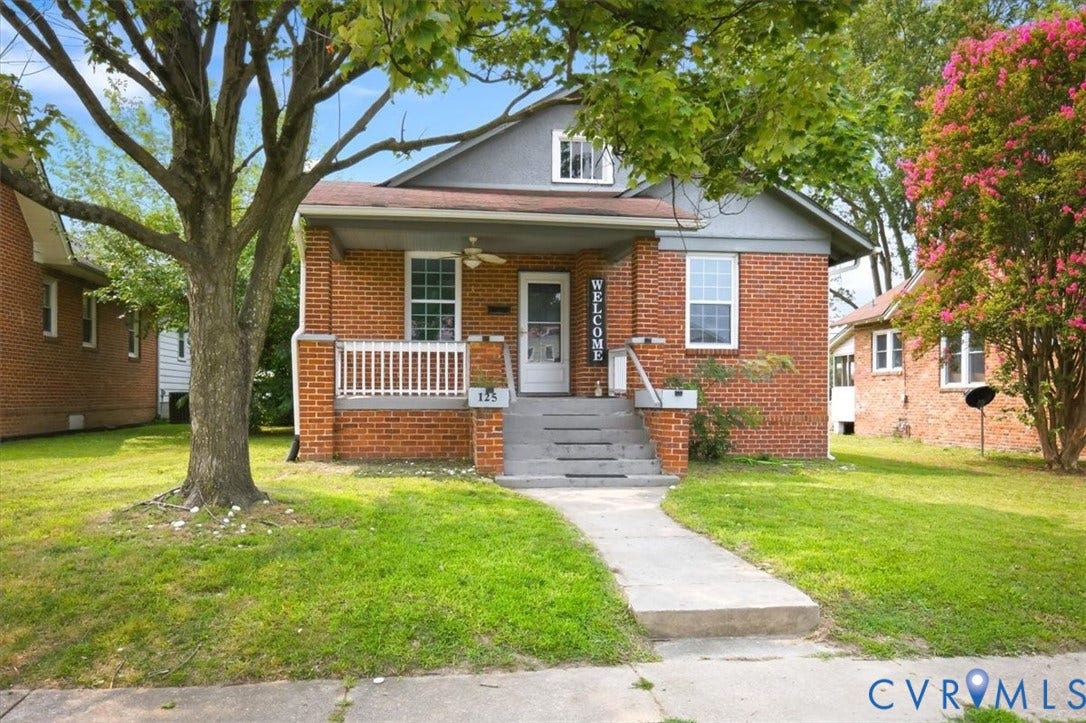 125 Richmond Avenue, Colonial Heights, VA 23834 Brick exterior residence featuring a covered front porch, white railing, and a gray shingle roof