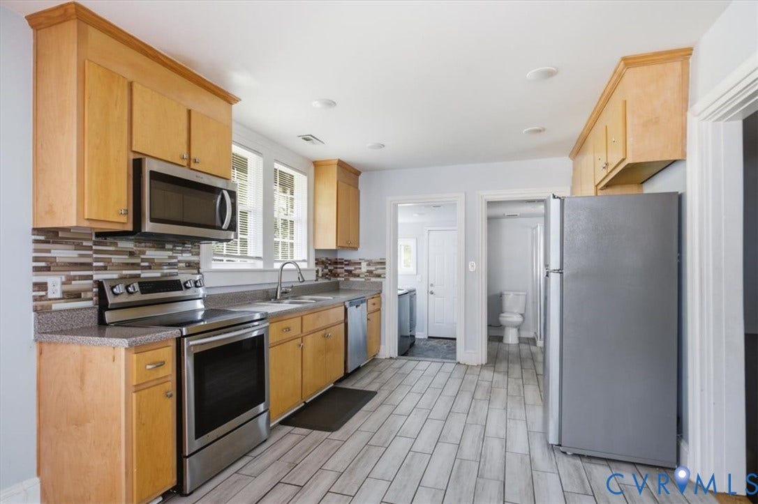 125 Richmond Avenue, Colonial Heights, VA 23834 Kitchen featuring light wood cabinetry with crown molding, stainless steel appliances, a mosaic tile backsplash, and light-toned tile flooring
