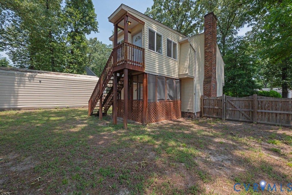 Two-story exterior featuring light-colored siding, an elevated wooden deck with stairs, and a screened-in porch