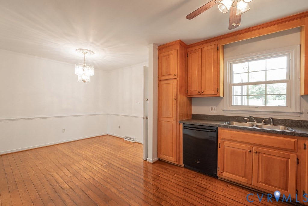Kitchen with wood-finish flooring, wood cabinetry, and a double basin sink