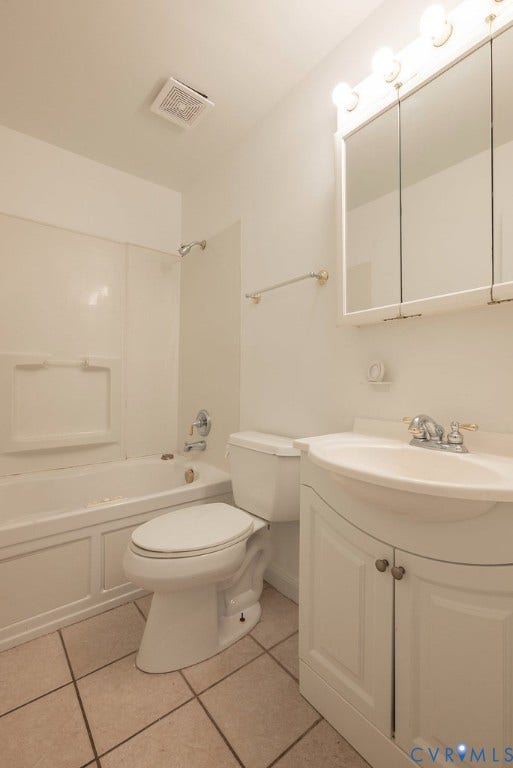Bathroom featuring a white vanity with cabinet storage, integrated sink, and a mirrored medicine cabinet with integrated lighting