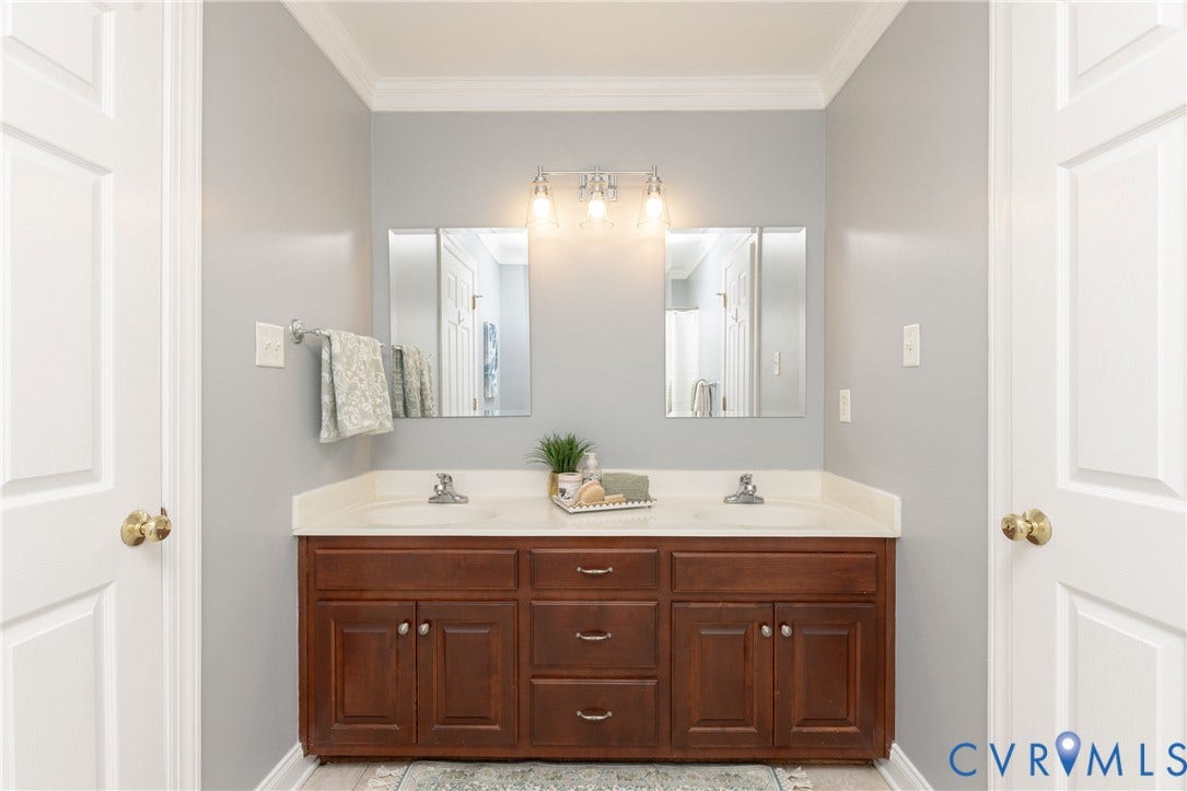 Double vanity with a light countertop and wood-finish cabinetry