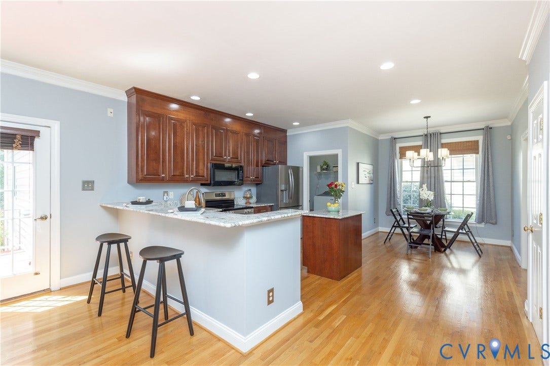 Kitchen featuring granite countertops, wood-finish flooring, recessed lighting, and rich wood cabinetry