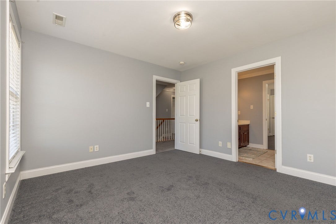 Carpeted room with light gray walls, white trim, and a semi-flush mount ceiling light fixture