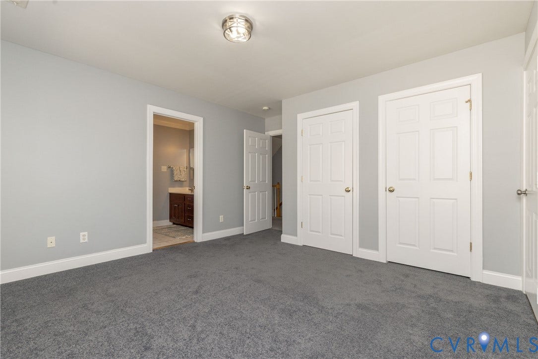 Carpeted room with light grey walls and white trim