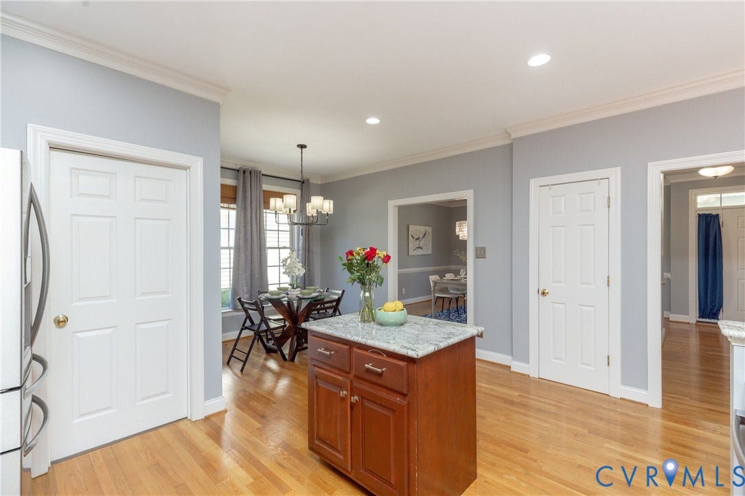 Kitchen featuring a wood-finish island with a light-colored countertop, recessed lighting, and wood-finish flooring