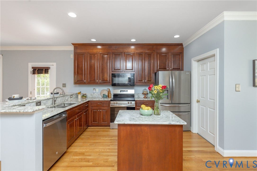 Kitchen featuring an island, light-toned wood-finish flooring, recessed lighting, and crown molding