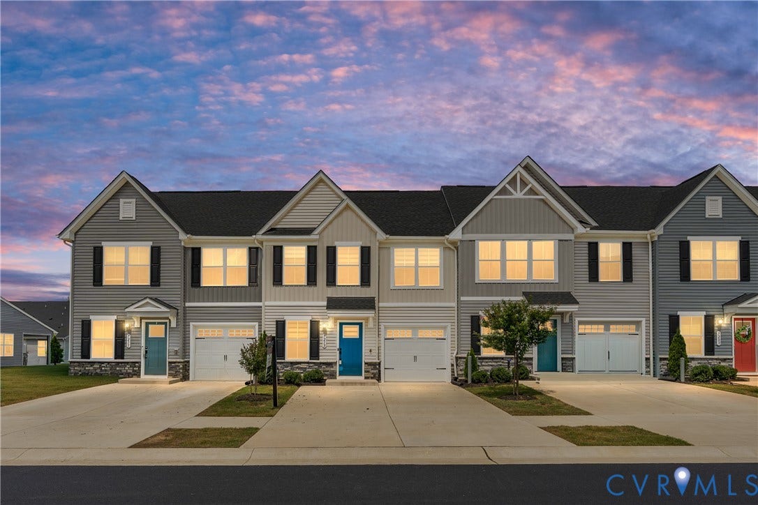 7213 Lyon Taylor Lane, Summer Maple, New Kent, VA 23124 Modern townhome exterior featuring gray siding, black shutters, a two-car garage, concrete driveway, and a vibrant turquoise entry door