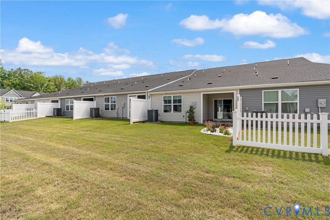7213 Lyon Taylor Lane, Summer Maple, New Kent, VA 23124 Shared backyard space featuring a manicured lawn, white picket fencing, and individual rear patios