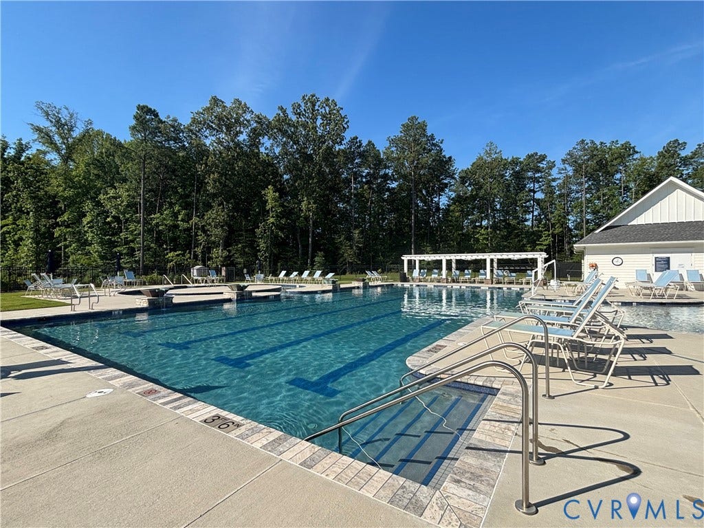 7213 Lyon Taylor Lane, Summer Maple, New Kent, VA 23124 Outdoor swimming pool with integrated lap lanes, surrounded by a concrete deck with brick-patterned coping
