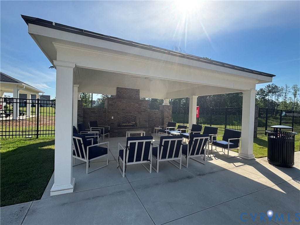 7213 Lyon Taylor Lane, Summer Maple, New Kent, VA 23124 Covered outdoor seating area featuring a stone-faced fireplace with a mantel