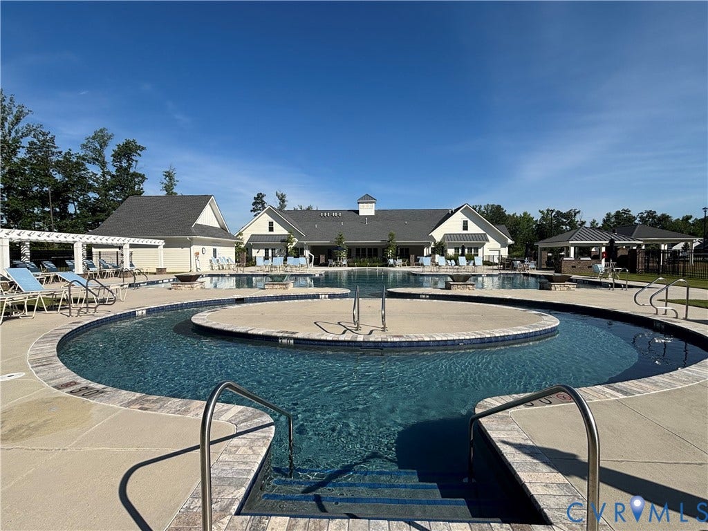 7213 Lyon Taylor Lane, Summer Maple, New Kent, VA 23124 Expansive resort-style swimming pool featuring integrated steps, stainless steel handrails, and a surrounding paver deck