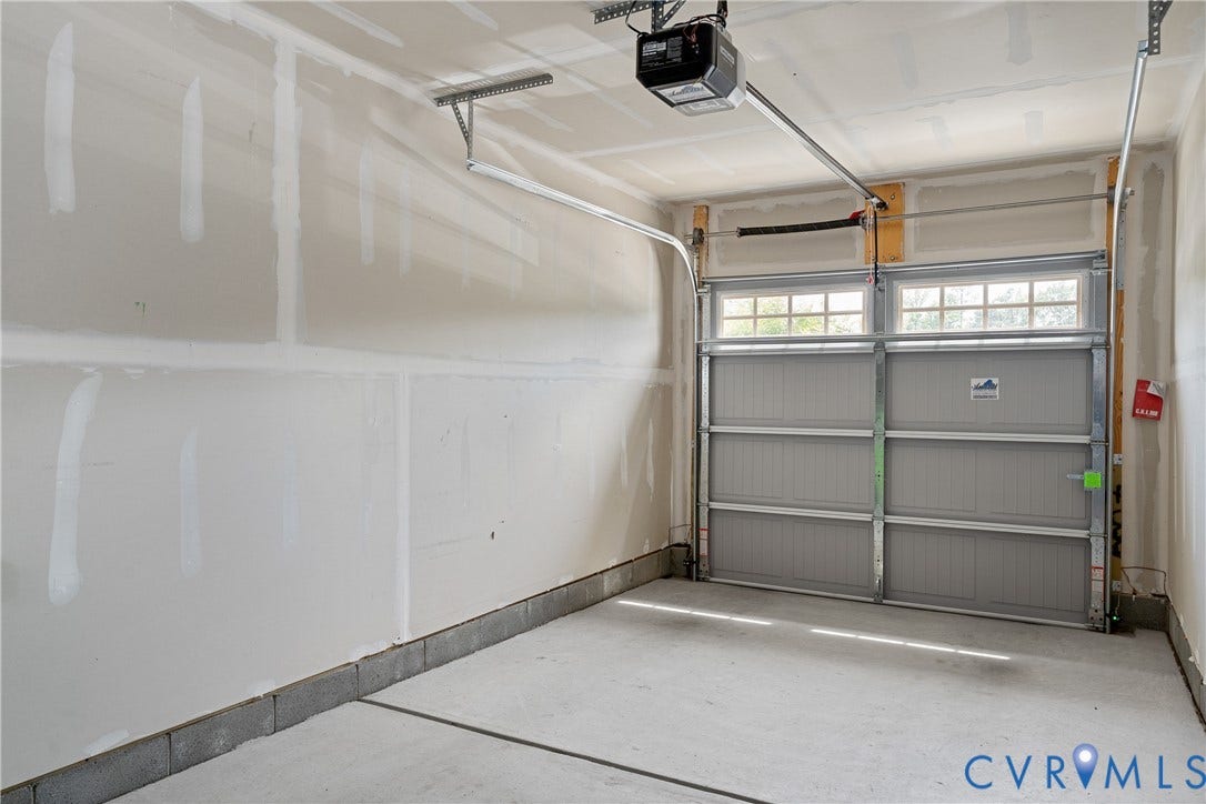 7213 Lyon Taylor Lane, Summer Maple, New Kent, VA 23124 Attached garage featuring a concrete floor, an automatic opener, and a panel-style garage door with integrated windows