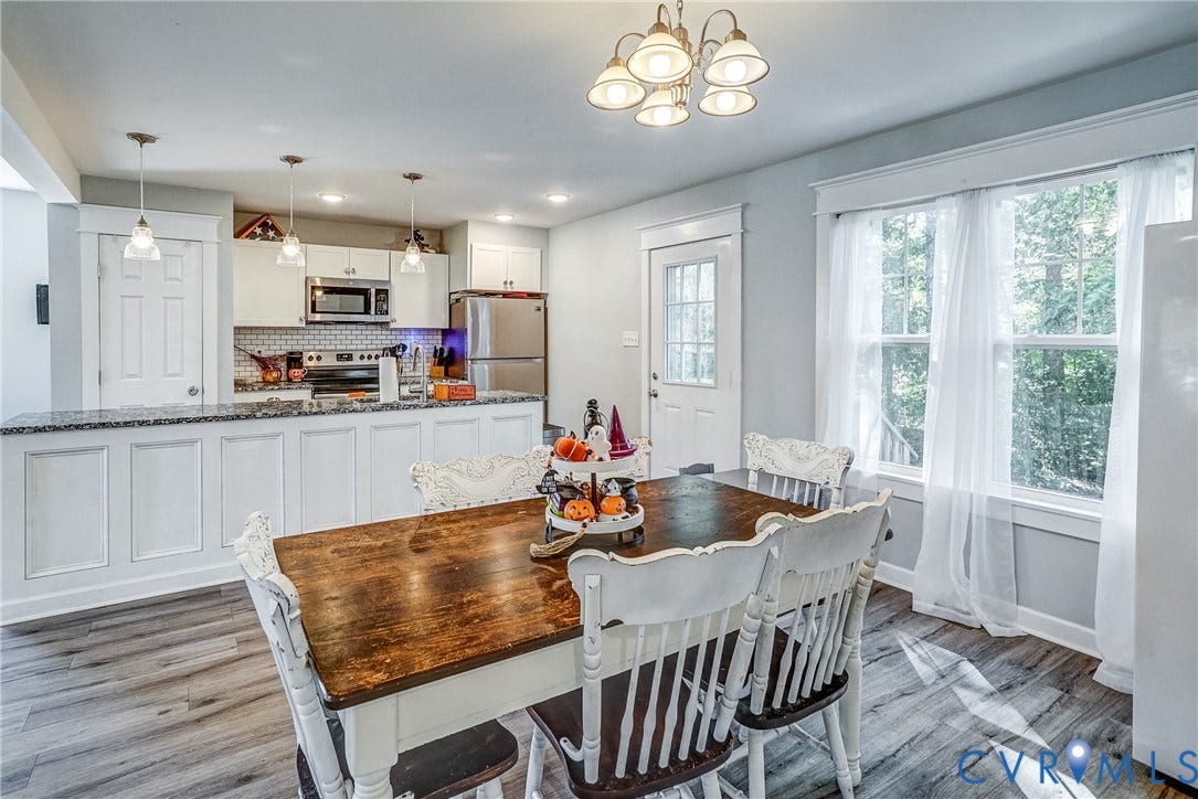 65 Hopeful Church Lane, Bumpass, VA 23024 Kitchen featuring a central island with a stone-look countertop, white paneled cabinetry, stainless steel appliances, and wood-finish flooring