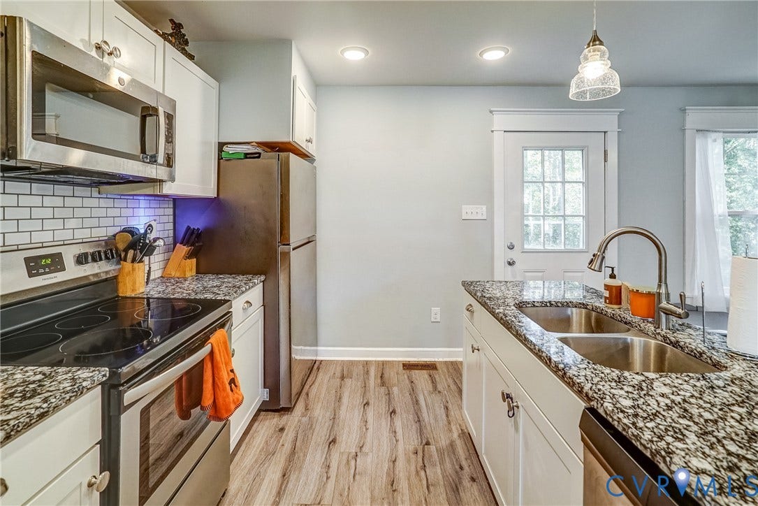 65 Hopeful Church Lane, Bumpass, VA 23024 Kitchen featuring a central island with a stone-look countertop, white paneled cabinetry, stainless steel appliances, and wood-finish flooring