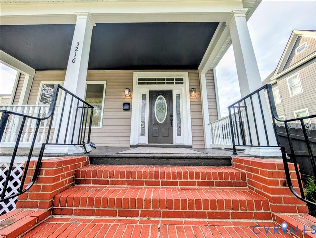 3216 Enslow Avenue, Richmond, VA 23222 Inviting entry featuring brick steps with wrought iron railings, a covered porch, white columns, and a dark front door with an oval glass insert