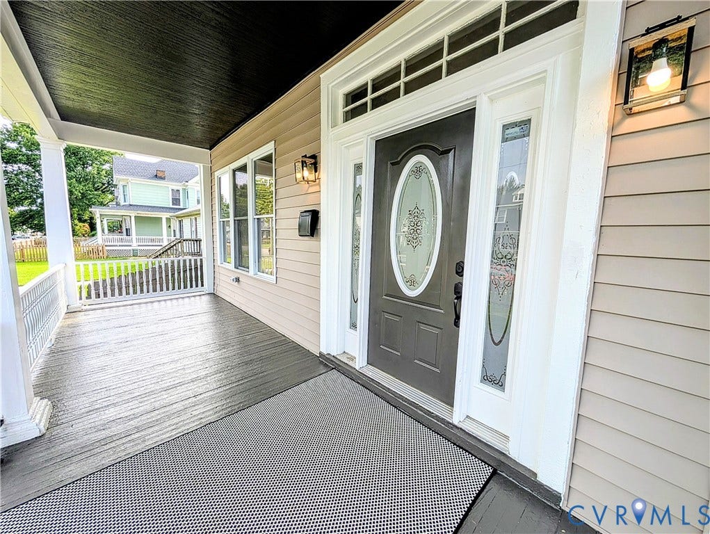 3216 Enslow Avenue, Richmond, VA 23222 Inviting covered front porch with dark wood-finish flooring, white railing, and exterior wall lighting