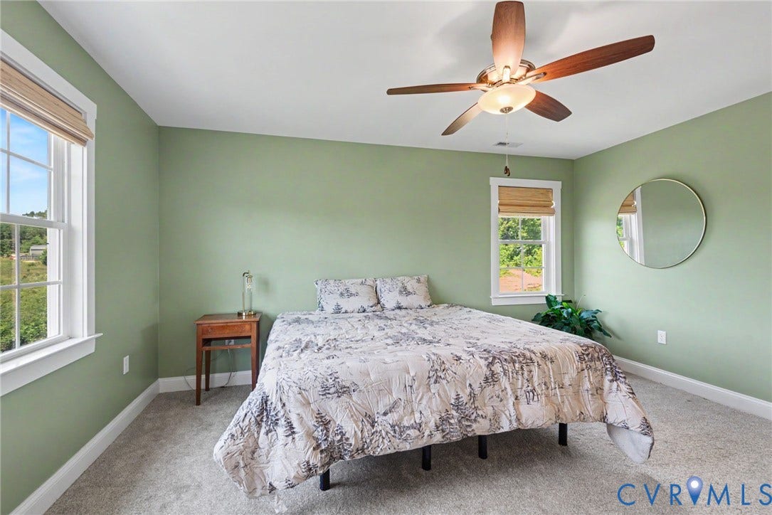 815 Kennon Road, Northeast Creek Reservoir Subd, Mineral, VA 23117 Carpeted room featuring light green walls, two windows with blinds, and a ceiling fan with light fixture