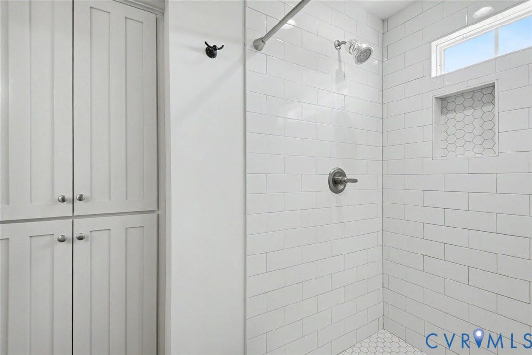 815 Kennon Road, Northeast Creek Reservoir Subd, Mineral, VA 23117 Shower stall with white subway tile, built-in niche with hexagonal tile, and upper transom window